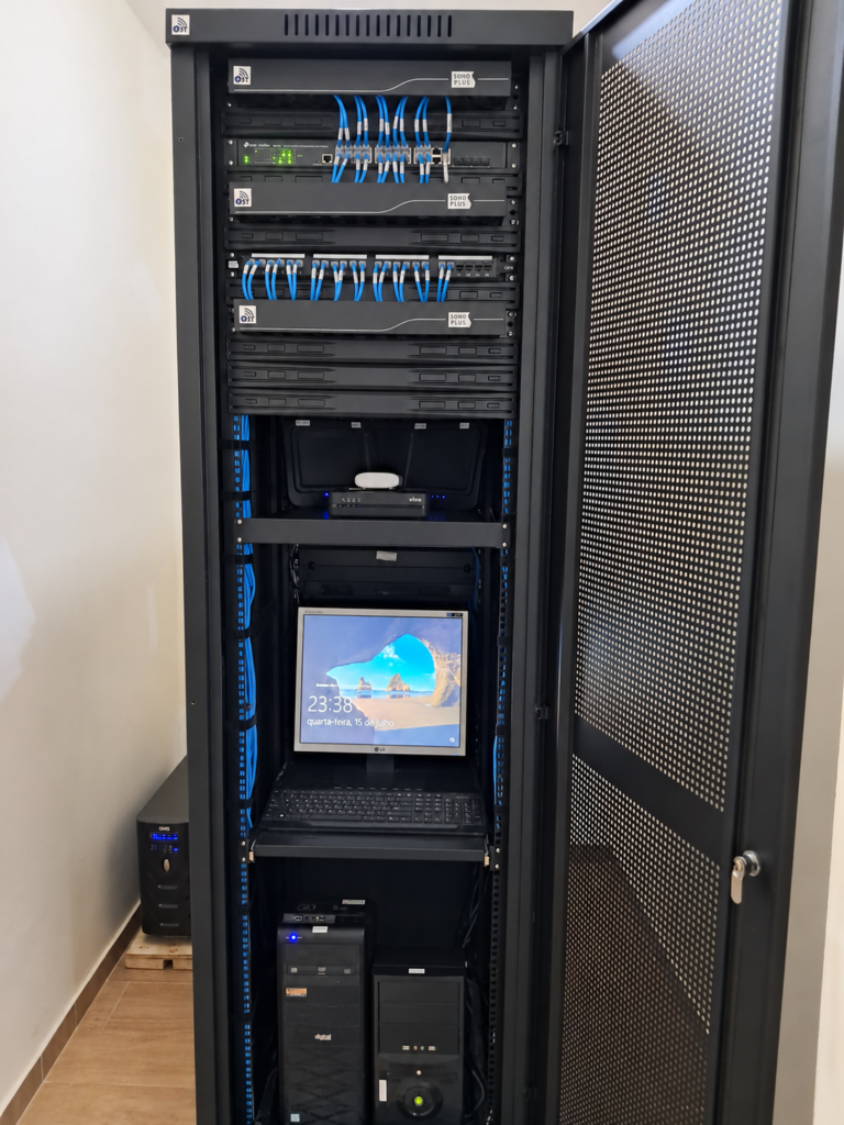 Rack com equipamentos de rede e cabos organizados.
